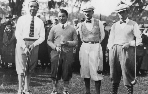 four men standing with golf clubs in 1930